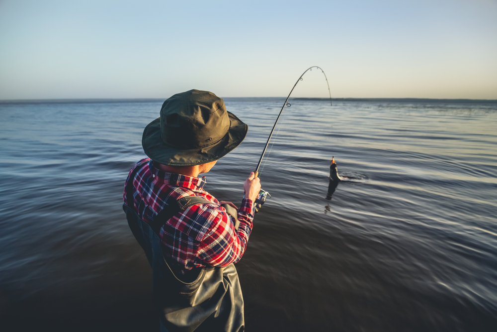 A,fisherman,with,a,fishing,rod,in,his,hand,and